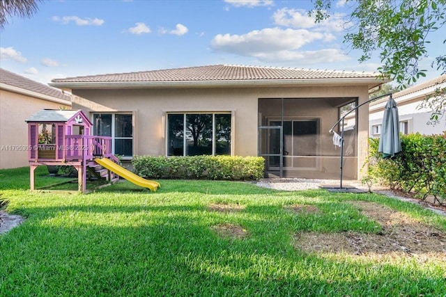 12471 NW 78th Mnr, Parkland, FL 33076 - back of house with a playground, a tiled roof, stucco siding, a yard, and a sunroom
