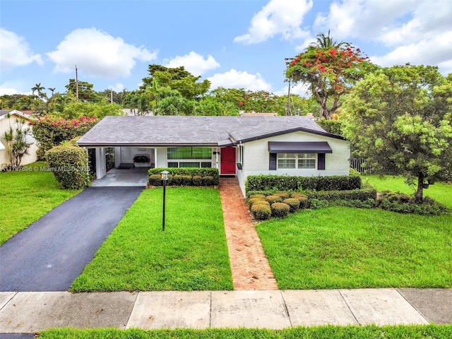 3921 Roosevelt St, Hollywood, FL 33021 - ranch-style house with a front yard, asphalt driveway, a carport, and brick siding