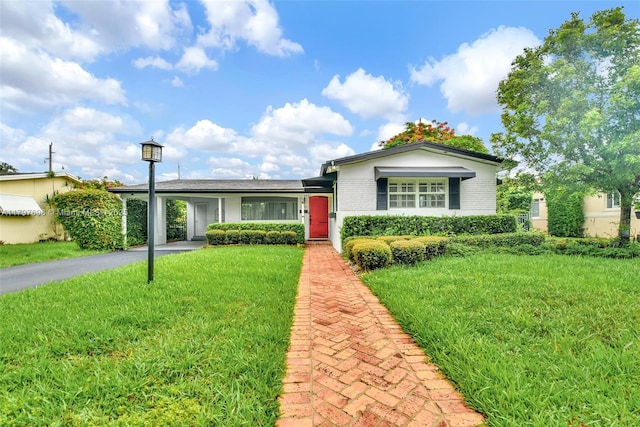 3921 Roosevelt St, Hollywood, FL 33021 - view of front facade featuring a front yard, driveway, a carport, and brick siding