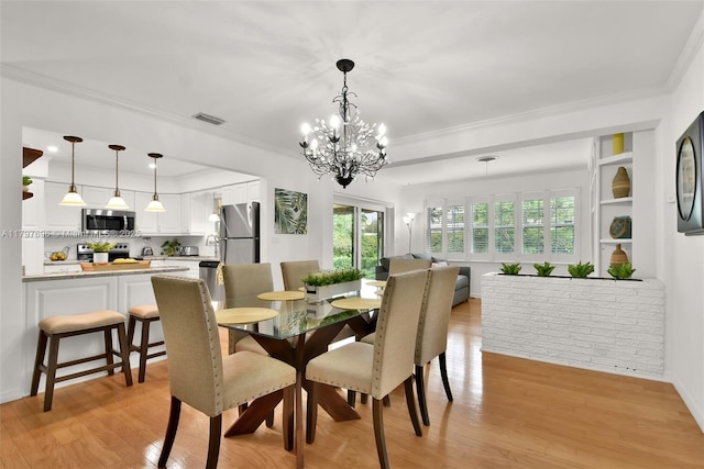 3921 Roosevelt St, Hollywood, FL 33021 - dining area with light wood-style floors, ornamental molding, a chandelier, and baseboards