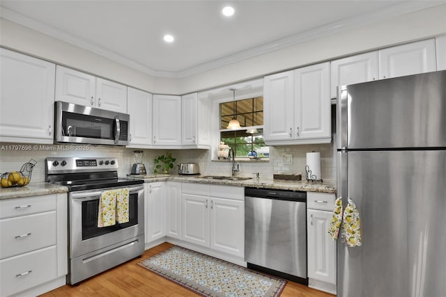 3921 Roosevelt St, Hollywood, FL 33021 - kitchen featuring stainless steel appliances, a sink, white cabinetry, backsplash, and ornamental molding