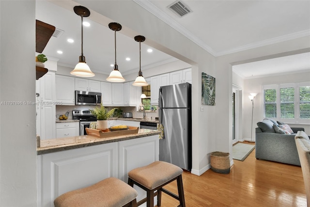 3921 Roosevelt St, Hollywood, FL 33021 - kitchen featuring stainless steel appliances, crown molding, open floor plan, a peninsula, and white cabinets