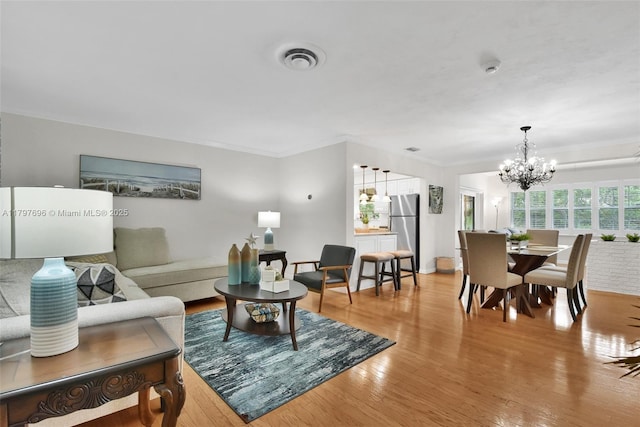 3921 Roosevelt St, Hollywood, FL 33021 - living area with a chandelier, light wood-style floors, and crown molding
