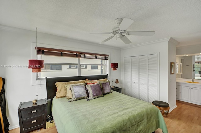 455 Paradise Isle Blvd Unit 209, Hallandale Beach, FL 33009 - bedroom featuring a sink, a closet, a textured ceiling, light wood finished floors, and crown molding