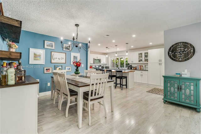 9652 NW 19th Pl, Sunrise, FL 33322 - dining area featuring light wood-style floors, a chandelier, a textured ceiling, recessed lighting, and baseboards