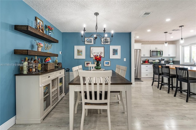 9652 NW 19th Pl, Sunrise, FL 33322 - dining space with a chandelier, light wood-type flooring, a textured ceiling, baseboards, and recessed lighting