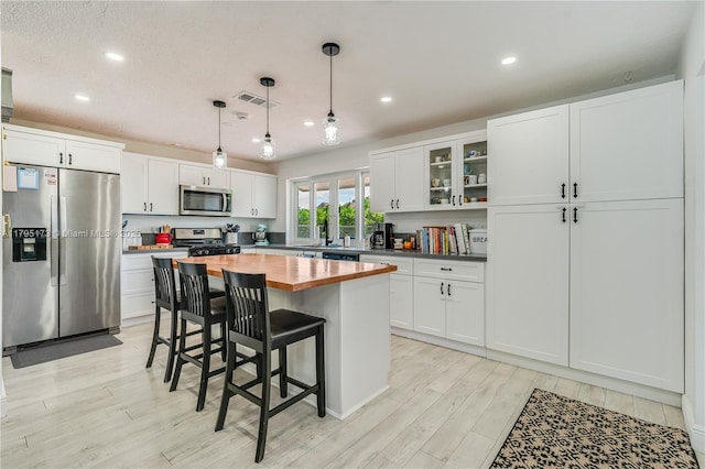 9652 NW 19th Pl, Sunrise, FL 33322 - kitchen with stainless steel appliances, wooden counters, a kitchen bar, light wood-style floors, and recessed lighting