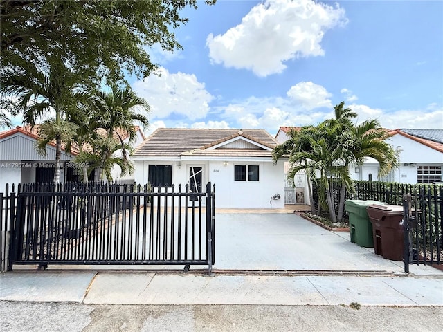 view of front of home featuring a tile roof, stucco siding, and a fenced front yard