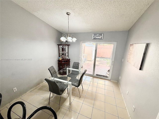 dining area with light tile patterned floors, a notable chandelier, a textured ceiling, and baseboards