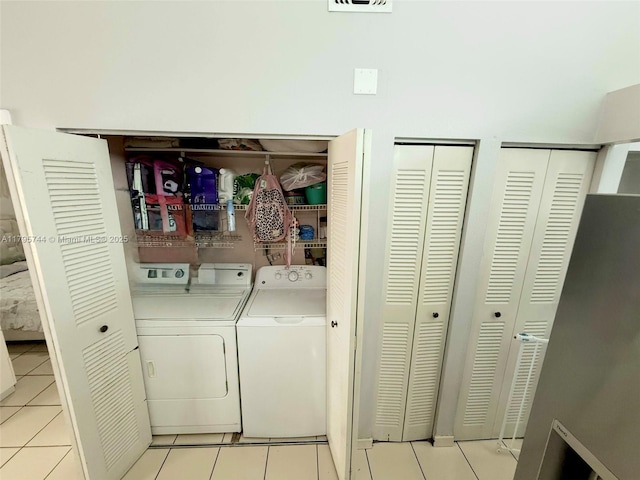 laundry area with separate washer and dryer, laundry area, and light tile patterned floors