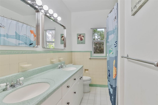 1254 Andalusia Ave, Coral Gables, FL 33134 - bathroom with tile walls, tile patterned floors, toilet, wainscoting, and double vanity
