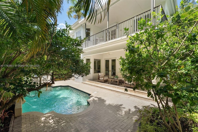 outdoor pool featuring an outdoor hangout area, a patio area, and french doors