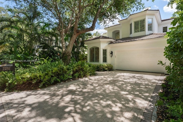 7251 SW 47th Ct, Miami, FL 33143 - mediterranean / spanish-style home with decorative driveway, a garage, stucco siding, and a tile roof