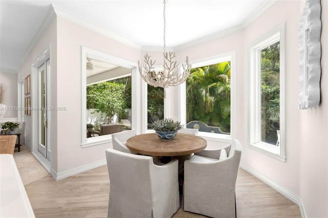 dining area featuring crown molding, a wealth of natural light, light wood-style flooring, and a notable chandelier