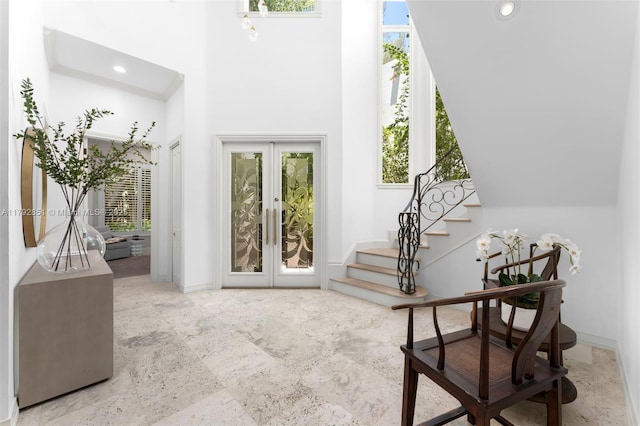 foyer featuring french doors, recessed lighting, baseboards, a towering ceiling, and stairway