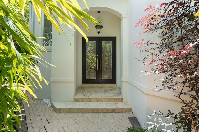 view of exterior entry with stucco siding and french doors
