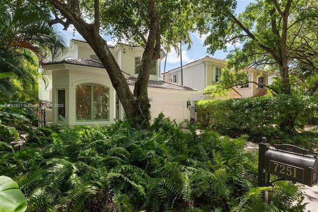 7251 SW 47th Ct, Miami, FL 33143 - view of side of home with a tiled roof, stucco siding, and a garage