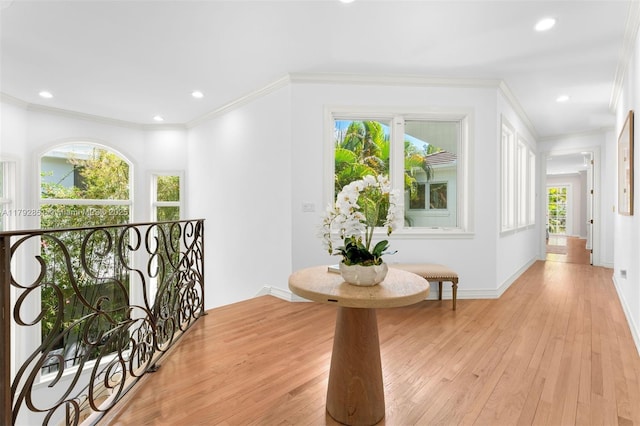 hallway featuring baseboards, recessed lighting, ornamental molding, and light wood-type flooring