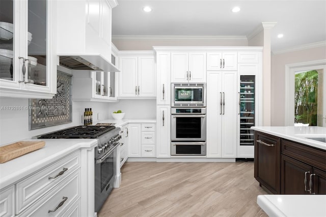 7251 SW 47th Ct, Miami, FL 33143 - kitchen with appliances with stainless steel finishes, white cabinetry, light countertops, light wood-style flooring, and ornamental molding
