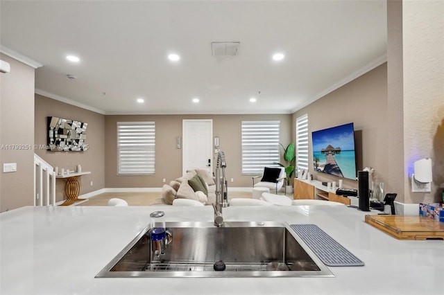 kitchen with a sink, visible vents, recessed lighting, crown molding, and open floor plan