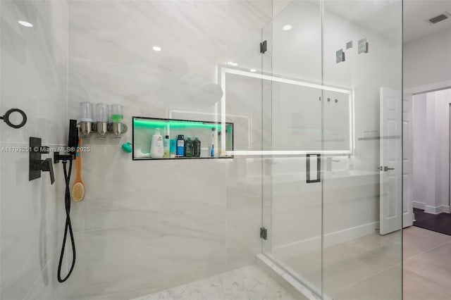 bathroom featuring tile patterned floors, visible vents, and a shower stall