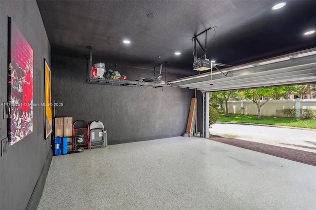 garage with recessed lighting and a garage door opener