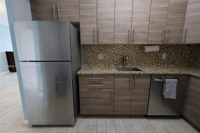 1985 S Ocean Dr Unit 21D, Hallandale Beach, FL 33009 - kitchen featuring appliances with stainless steel finishes, light wood-type flooring, tasteful backsplash, light stone counters, and modern cabinets