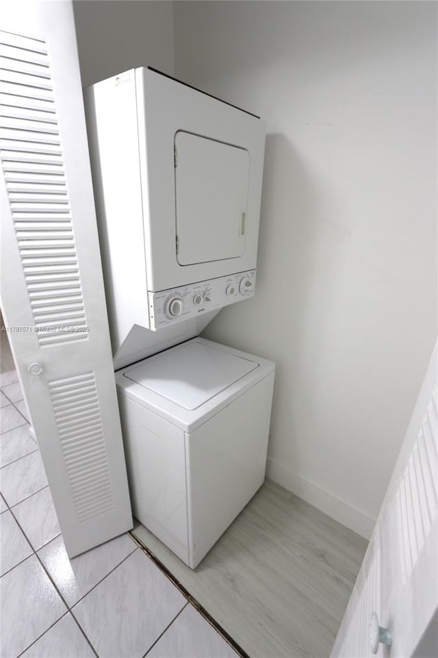 laundry room with laundry area, baseboards, and stacked washer and dryer