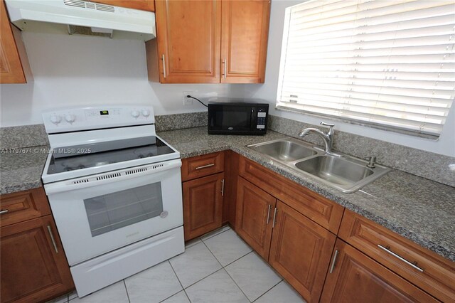 kitchen featuring a sink, light tile patterned flooring, under cabinet range hood, black microwave, and white range with electric stovetop