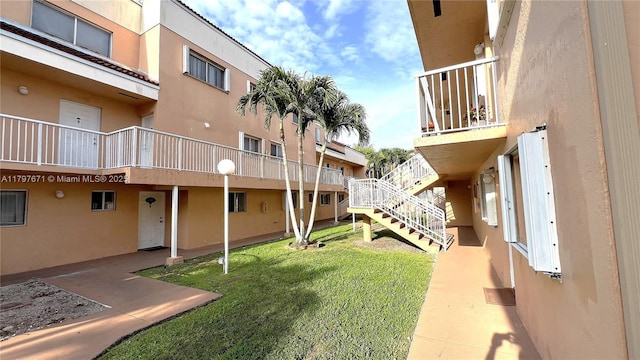 view of property's community featuring stairs and a lawn