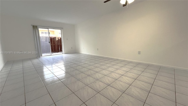 spare room featuring light tile patterned floors, baseboards, and ceiling fan
