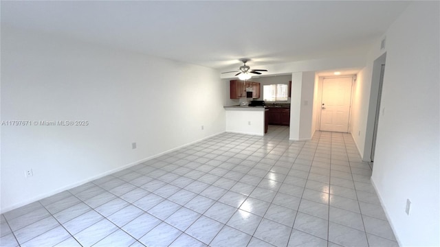 unfurnished living room with baseboards, a ceiling fan, and light tile patterned floors