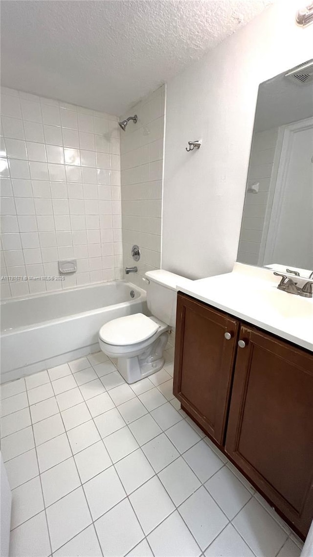 bathroom with toilet, vanity, a textured ceiling, tile patterned floors, and  shower combination