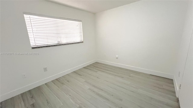 empty room with light wood finished floors and baseboards