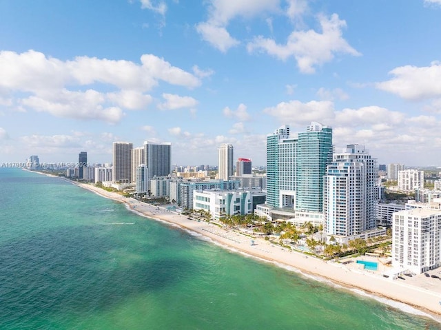 bird's eye view with a water view, a view of city, and a view of the beach