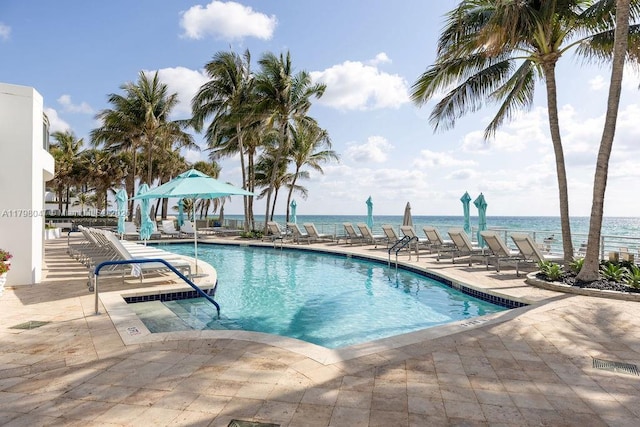 pool with a water view and a patio area