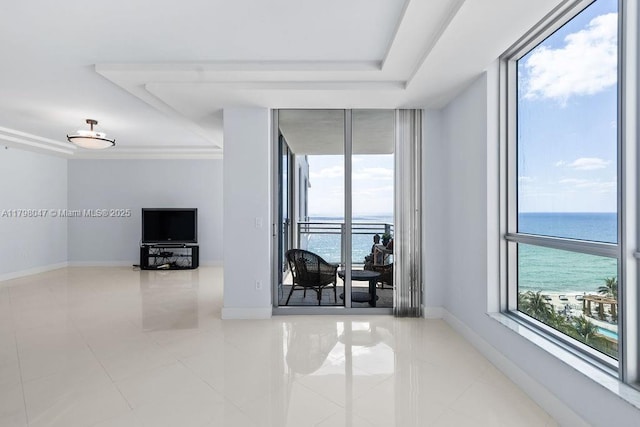 living room featuring tile patterned floors, a raised ceiling, and a healthy amount of sunlight