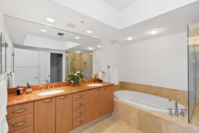 bathroom with a sink, double vanity, a stall shower, and visible vents