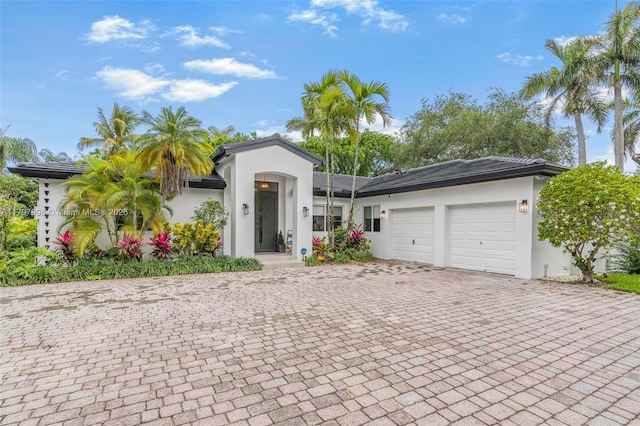 7560 SW 144th St, Palmetto Bay, FL 33158 - view of front of house featuring a garage, stucco siding, and decorative driveway