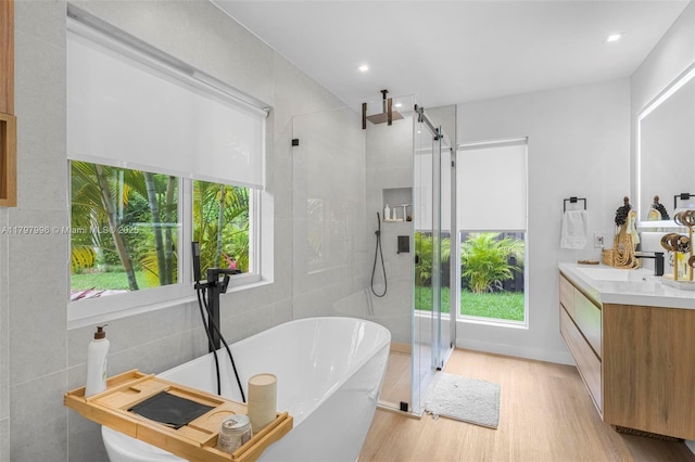 7560 SW 144th St, Palmetto Bay, FL 33158 - bathroom with a soaking tub, a wealth of natural light, wood finished floors, and a shower stall