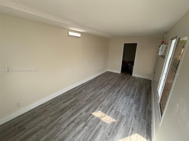 unfurnished room with baseboards and wood finished floors
