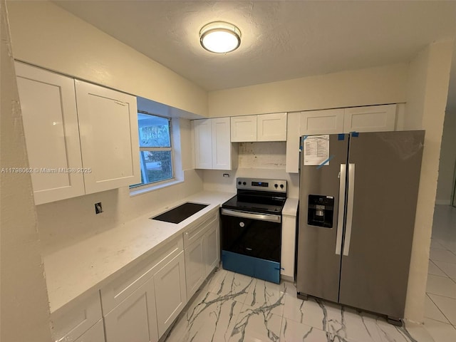kitchen with a sink, stainless steel appliances, white cabinets, light countertops, and marble finish floor