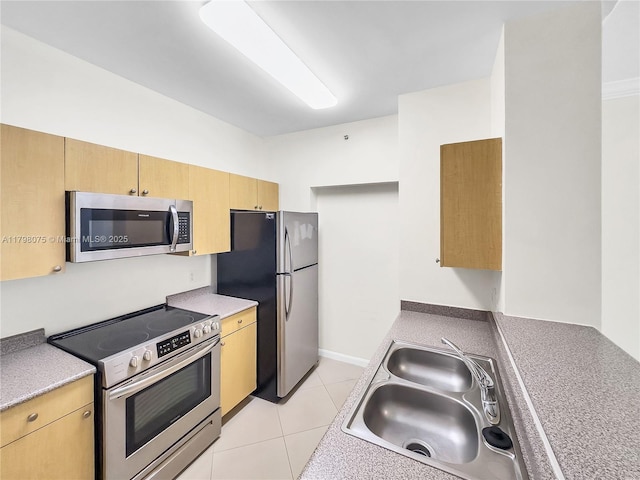kitchen with a sink, stainless steel appliances, light brown cabinetry, and light tile patterned flooring