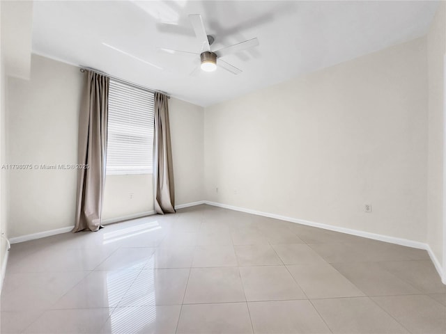 empty room featuring light tile patterned flooring, baseboards, and a ceiling fan