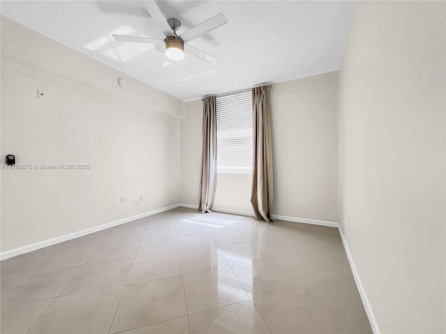 spare room featuring baseboards, light tile patterned floors, and ceiling fan