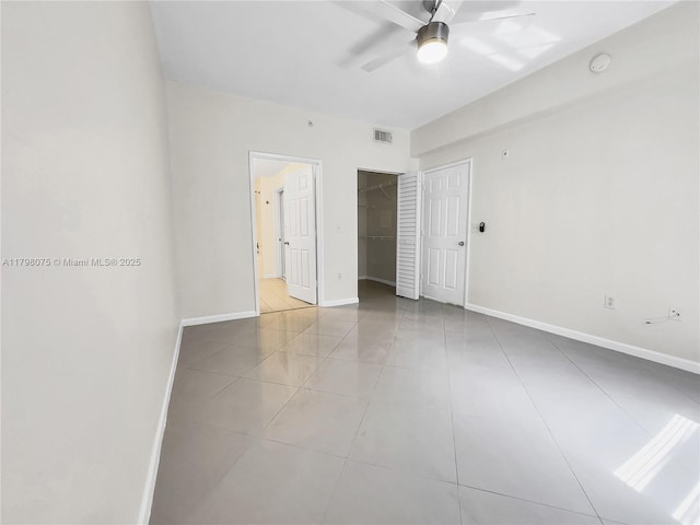 unfurnished bedroom featuring a closet, light tile patterned floors, visible vents, and baseboards