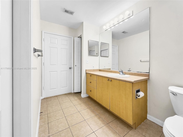 bathroom featuring toilet, tile patterned flooring, visible vents, and baseboards