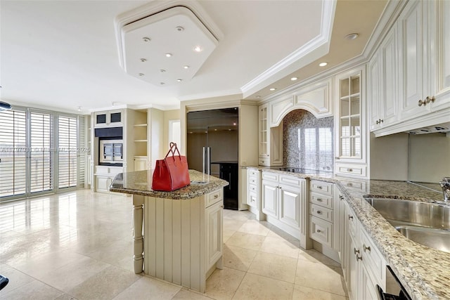19667 Turnberry Way Unit 16Gr, Aventura, FL 33180 - kitchen with backsplash, a sink, plenty of natural light, ornamental molding, and a kitchen island