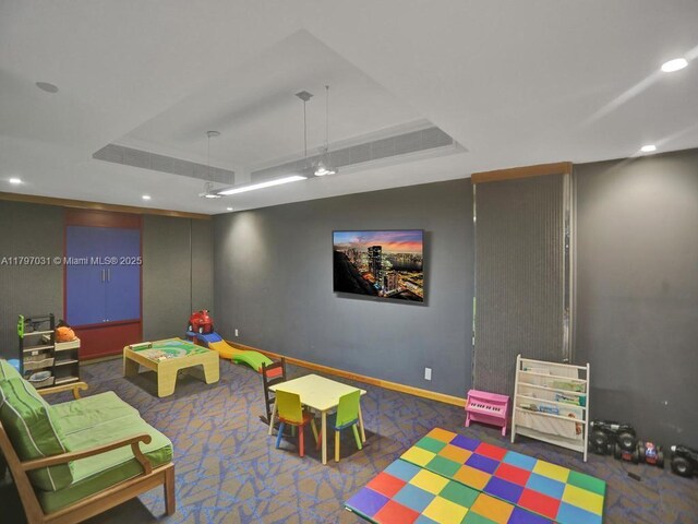 playroom with a tray ceiling, carpet flooring, baseboards, and recessed lighting