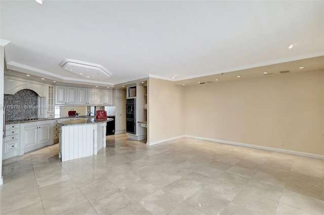19667 Turnberry Way Unit 16Gr, Aventura, FL 33180 - kitchen featuring a center island, ornamental molding, dark stone counters, open floor plan, and recessed lighting